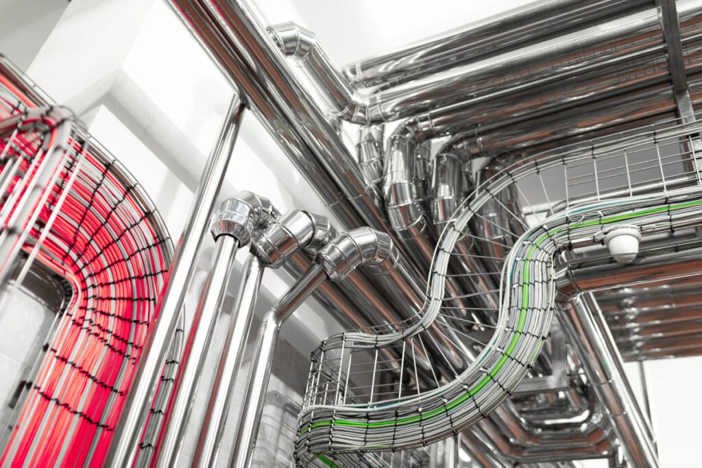 Industrial pipelines and modern equipment in cheese production interior