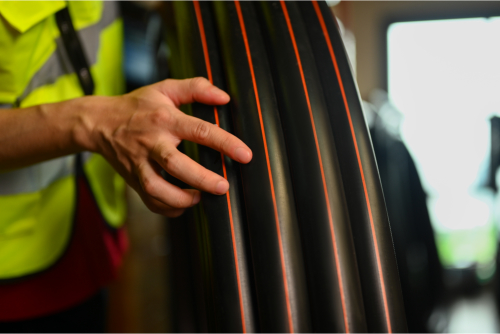 man holding pipes, checking product material