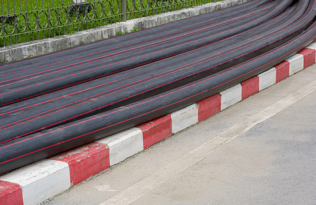 pile of many hdpe pipes conduit on footpath Coastal Resources Group
